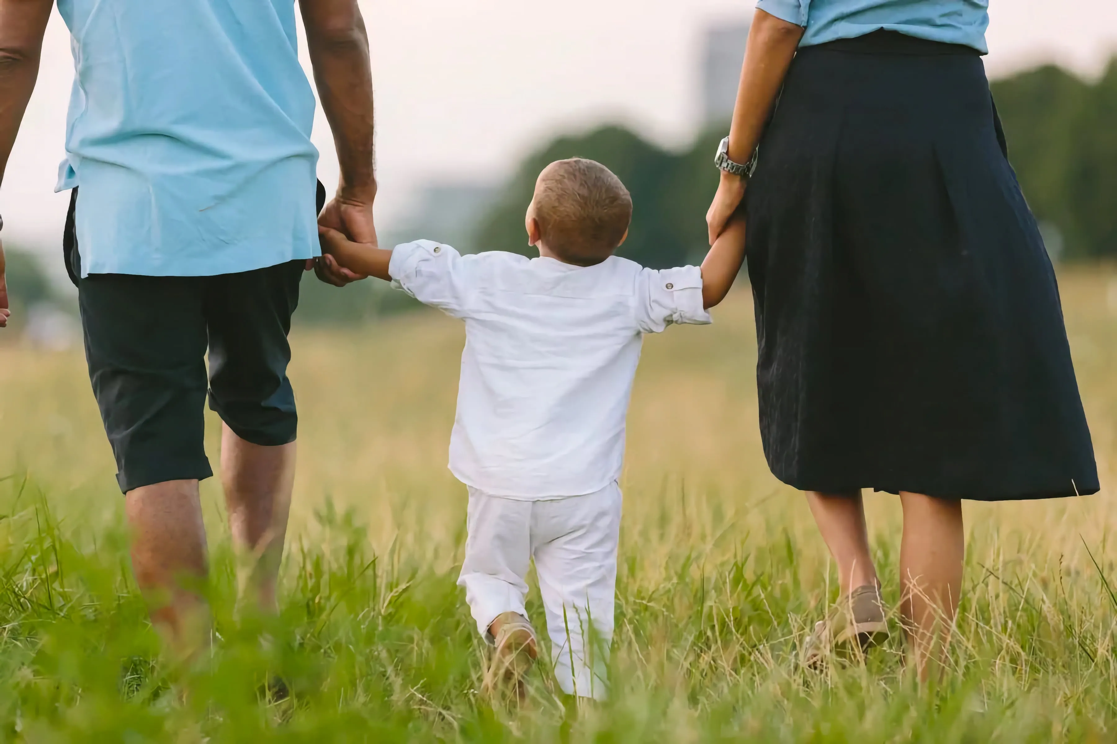 Family of three walking together in a field