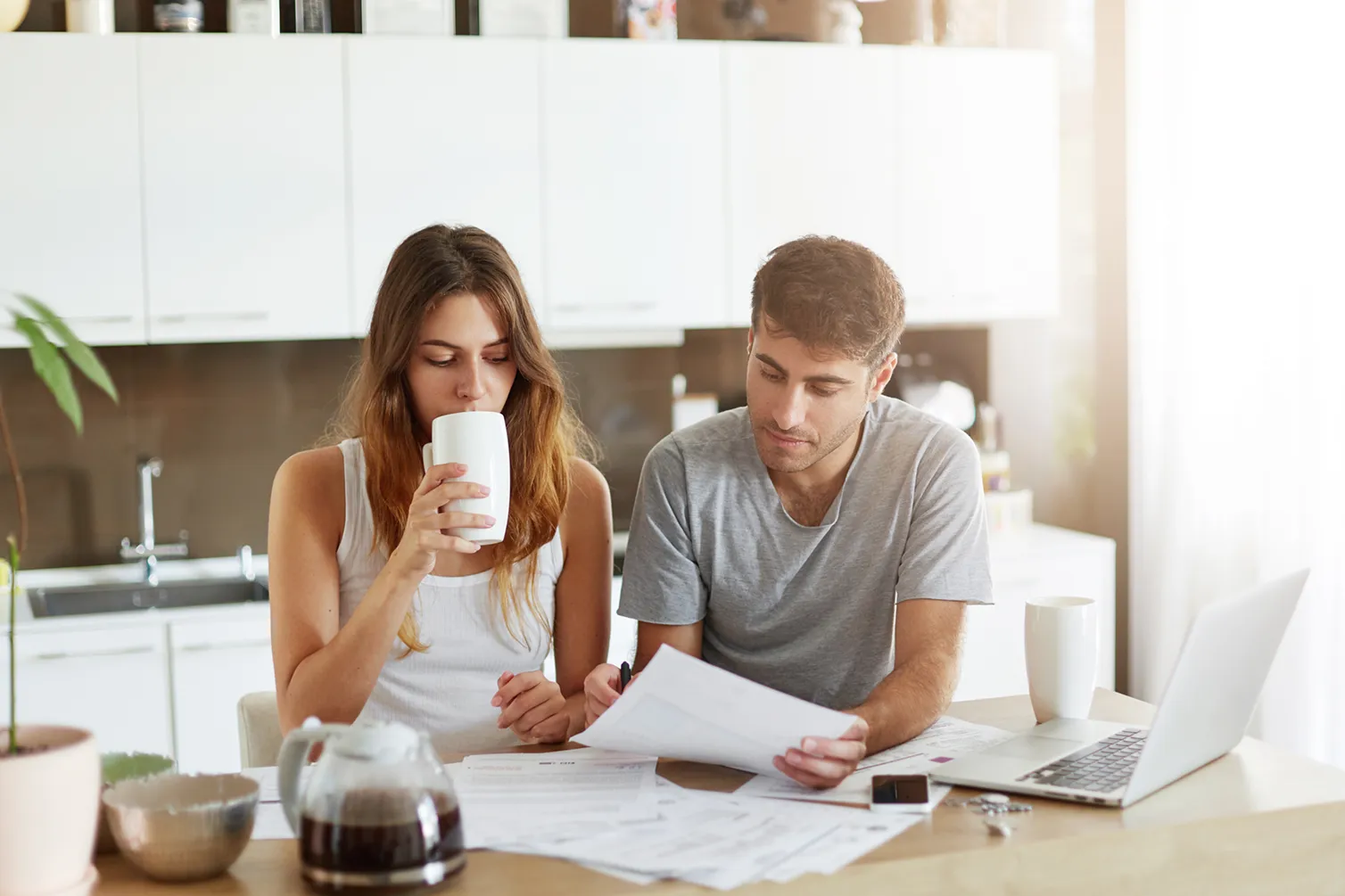 Cohabiting couple reviewing paperwork at the kitchen table, highlighting the need for cohabitation reform.